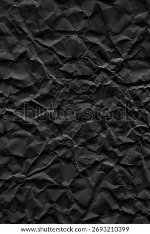 Flatbed scanner scan of crumpled matte black paper with deep creases, random folds and strong shadow variation, vertical format. Compared to the companion horizontal scan, the crumpling here is more dramatic with sharper, deeper fold lines creating stronger contrast between peaks and valleys. The matte black surface absorbs light unevenly across the folds, producing a wide tonal range from near-black in the deepest shadows to lighter gray on raised surfaces. No AI, no digital generation, no 3D rendering. 5000x7500px at 300dpi, print-ready. Works as background, overlay or displacement map for dark poster design, album covers, packaging, fashion editorial and product mockups. The deep crease pattern creates strong compositional movement and depth. Particularly effective as a displacement map in Photoshop for wrapping text or graphics onto a heavily crumpled surface.