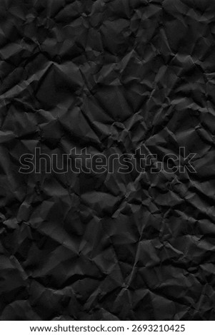 Flatbed scanner scan of crumpled matte black paper with deep creases, random folds and strong shadow variation across the surface. The crumpling creates a three-dimensional relief visible as tonal contrast between raised peaks and folded valleys. Matte black paper absorbs light differently from standard paper, giving the shadows extra depth. No AI, no digital generation, no 3D rendering. 5000x7500px at 300dpi, print-ready. Works as background, overlay or displacement map for dark poster design, album covers, packaging, editorial and product mockups. The crease pattern gives natural compositional movement and depth. Also useful as a displacement map in Photoshop for wrapping text or graphics onto a crumpled surface.