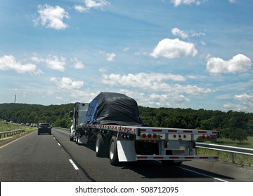 Flatbed Semi Transporting Covered Freight