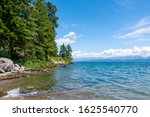 Flathead Lake Montana during summer with pine trees lining the shore. Flathead Lake is the largest natural lake in Montana USA.