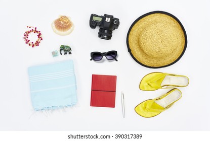 Flatlay From Above White Beach With Hat Sandals Towel Sunglasses Camera