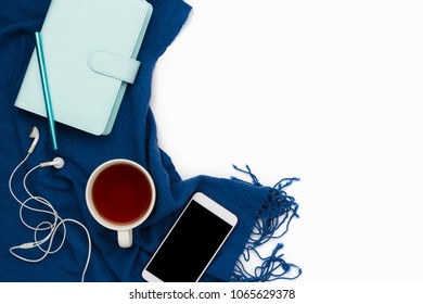 Flatlay Arrangement With Blue Planner, Smartphone With Headphone And Black Copyspace Screen And Cup Of Tea, Working Space Mockup.