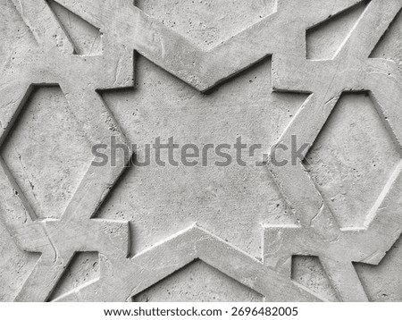 Flat-lay background of an Islamic geometric pattern carved into raw, grey concrete. The intricate, repeating lines and stars create a modern, minimalist texture. Perfect for Islamic architecture 