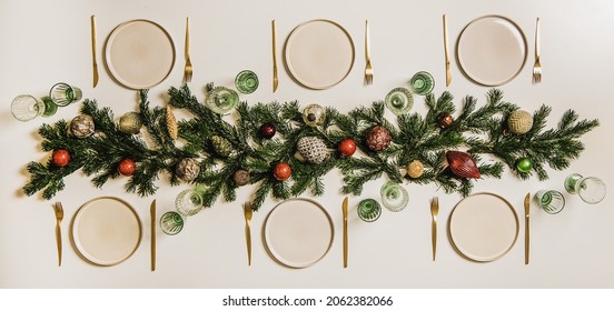 Flat-lay Of Christmas Table Setting With White Dinnerware And Branches