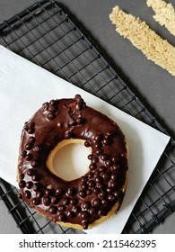 flatlay and close up view of crispy chocolate chip donut coated with melted chocolate