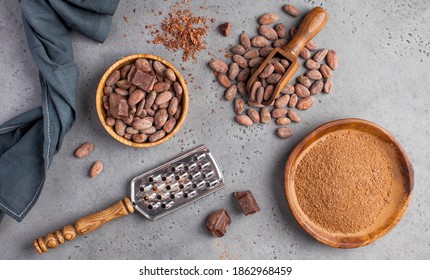 Flatlay Cocoa Beans, Cocoa Powder, Raw Chocolate On A Gray Background. The Concept Of Healthy Eating. 