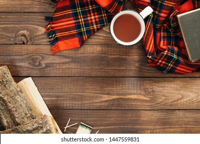 Flatlay Composition With Red Scarf, Cup Of Tea, Firewood, Book On Wooden Desk Table. Hygge Style, Cozy Autumn Or Winter Holiday Concept. Flat Lay, Top View, Overhead. 