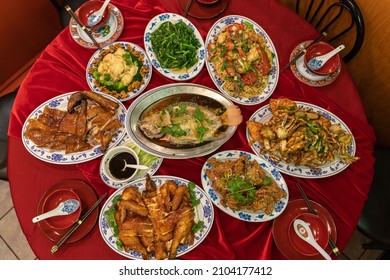 Flatlay of a full table spread containing traditional dishes for Chinese Lunar New Year. Each dish has a symbolic meaning for the celebration. - Shutterstock ID 2104177412