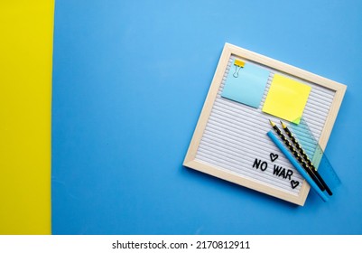 Flatlay Horizontal Composition Empty Letter Board With The Words No War, Pray For Ukraine, Patriotic Colors Blue And Yellow Sticker, Black Pencils And Ruler, Empty Blue Background