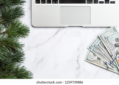 Flatlay Items: Laptop, Christmas Tree, Cash Money Lying On White Marble Background. Top View