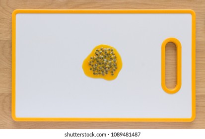 Flatlay Of Passionfruit Seeds On A White Cutting Board