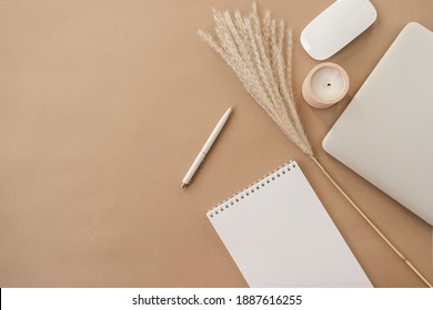 Flatlay of spiral flip notebook with blank paper sheet. Laptop, pampas grass, stationery on beige peachy pastel background table. Minimalist home office desk workspace. Top view mockup copy space. - Shutterstock ID 1887616255