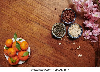 Flatlay Of Table Served For Tet Celebration With Plate Of Tangerines And Bowls With Seeds