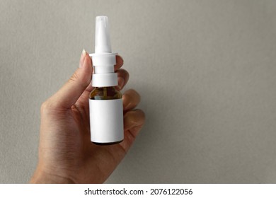 Flatlay Top View Person Hand Holding Nasal Spray In Glass Bottle With Blank Label For Medical Purpose And Prevention From Covid-19 Coronavirus Or Sinusitis, Nose Multiple Problem. Healthcare Concept