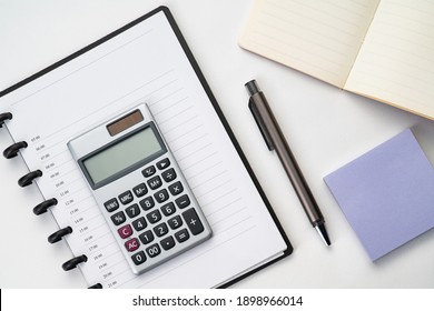 Flatlay Topview Of Working Table Including Pen , Note , Calculator And Sticky Note Isolated 