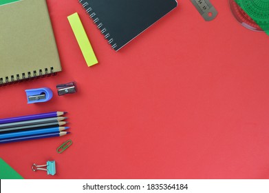 Flatlay View Of School And Office Stationary Isolated On A Red Background. Notebook, Colours, Rulers,  And Other Tools.  Education Concept. Top View.