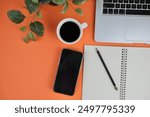 flatlay of a workplace with A cup of coffee, a laptop and a notebook, on a plain background. Education, business and office concept. 