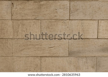 Flat-on architectural backdrop featuring rectangular beige sandstone blocks in a clean ashlar masonry pattern. Smooth chiseled stone surface providing layout copy space.