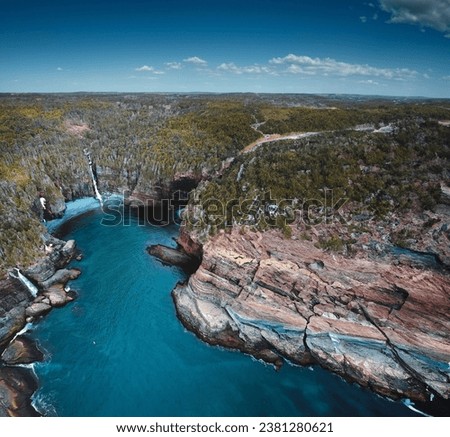 Flatrock, NL, Canada Rough cliff covered with trees in front of ocean Drone Shot