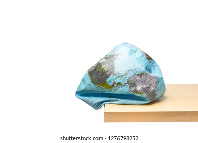 Flattening globe earth at the edge of wood table on white background, Environmental damage concept, Earth in danger concept