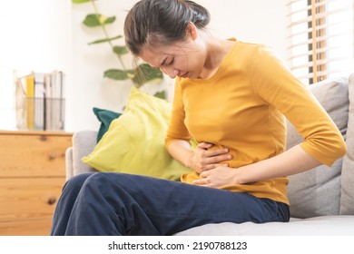 Flatulence asian young woman, girl hand in stomach ache, suffer from food poisoning, abdominal pain and colon problem, gastritis or diarrhoea. Patient belly, abdomen or inflammation, concept.
