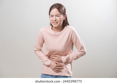 Flatulence asian young woman intolerance hand in stomach ache, suffer from food poisoning, abdominal pain and colon problem, gastritis or diarrhoea when at home. Patient belly, abdomen or inflammation - Powered by Shutterstock