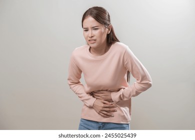 Flatulence asian young woman intolerance hand in stomach ache, suffer from food poisoning, abdominal pain and colon problem, gastritis or diarrhoea when at home. Patient belly, abdomen or inflammation - Powered by Shutterstock