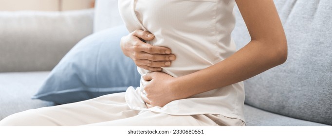 Flatulence ulcer, asian young woman, girl hands in belly, stomach pain from food poisoning, abdominal pain and digestive problem, gastritis or diarrhoea. Abdomen inflammation, menstrual period people. - Powered by Shutterstock