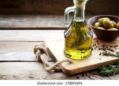 Flavored olive oil with rosemary and pepper on wooden background. Copy space. - Powered by Shutterstock