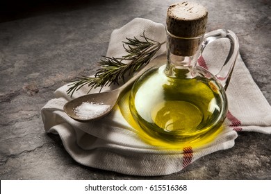 Flavored olive oil with rosemary and pepper on stone and wooden table - Powered by Shutterstock