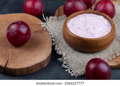 flavored pink yogurt with ripe and sweet plum, preparation of dairy products with aroma and pieces of red plum