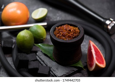 Flavored Tobacco For Hookah And Fruits On A Black Stone Background