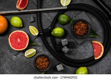 Flavored Tobacco For Hookah And Fruits On A Black Stone Background