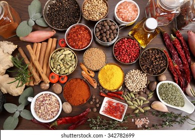 Flavorful, colorful spices in metal  bowls and glass bottles on dark wooden background. - Shutterstock ID 342782699