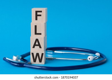 Flaw word written on wooden blocks and stethoscope on light blue background. Healthcare conceptual for hospital, clinic and medical busines.