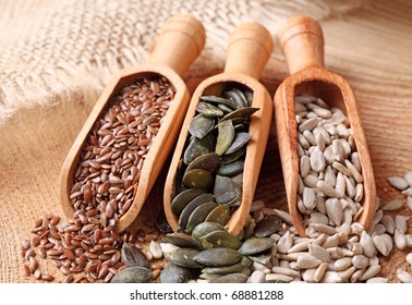 Flax, Pumpkin And Sunflower Seeds In Wooden Spoons