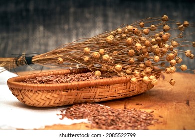 Flax Seeds In Wooden Basket And Dry Flax Plant Stems, Selective Focus, Close Up.