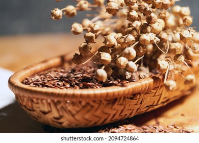 Flax Seeds In A Wooden Basket And Dry Flax Plant Stem, Selective Focus, Close Up.