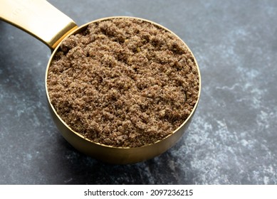 Flaxseed Meal  In A Gold Measuring Cup