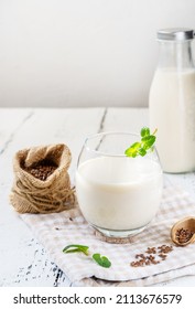 Flaxseed Milk In Glass And Bottle, Sackcloth With Seeds, Mint Leaves, Napkin