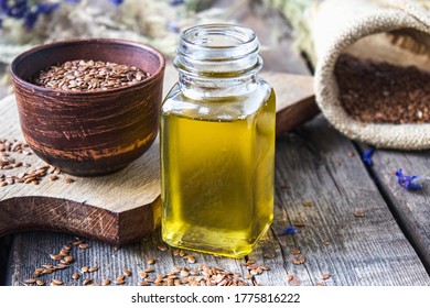Flachsöl in einer Flasche nahe Flaxsaat auf einem Holztisch. Flaxsaatöl wird beim Kochen, in der Medizin, in der Kosmetologie verwendet.