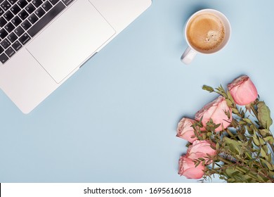 Flay Lay Cup Of Black Coffee, Laptop And Roses On Blue Paper Background