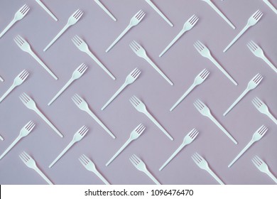 Flay lay photo of white plastic disposable forks. Creative top view pattern.