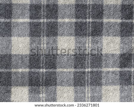 Fleece texture background with plaid pattern of grey dark grey and light grey colors. Gray fleece fabric texture with checkered pattern