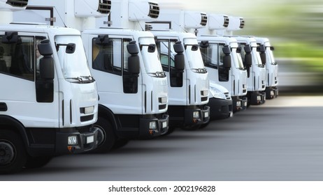 A Fleet Of Delivery Truck Vehicles Used To Transport Refrigerated Goods, High Dynamic, Motion Blurred. 