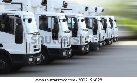 A fleet of delivery truck vehicles used to transport refrigerated goods, high dynamic, motion blurred. 