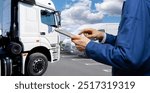 Fleet manager with digital tablet on a background of trucks