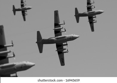 A fleet of transport planes flying overhead. (Shot with minimum depth of field. Focus is on the centre aircraft.)