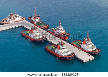 Fleet of tug boats moored in a port. Aerial view