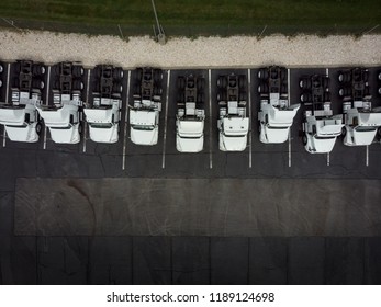 Fleet of white 18-wheeler semi-trucks overhead view drone photography	
